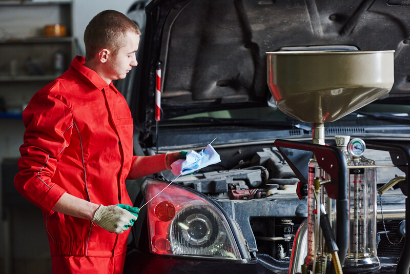 Auto mechanic performing an oil change