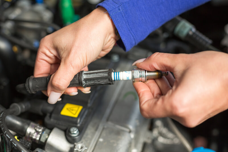 Auto mechanic inspecting spark plugs