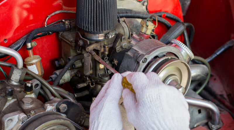 Auto mechanic adjusting a carburetor