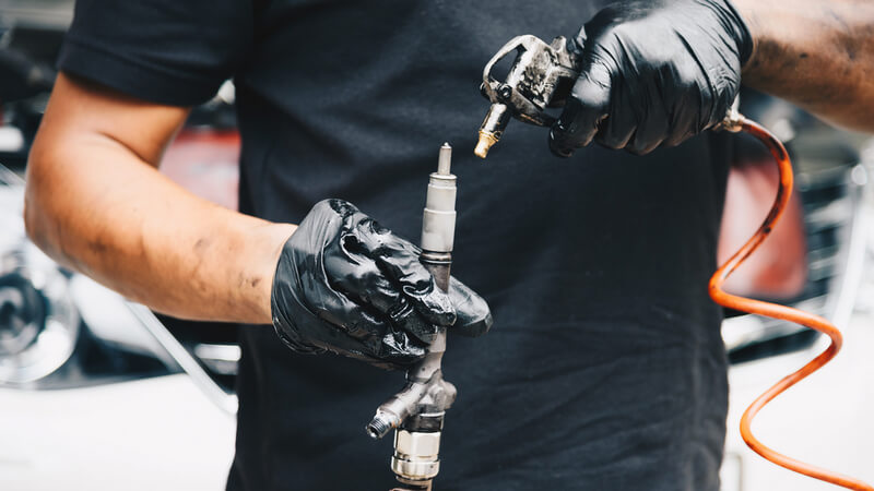 Auto mechanic cleaning injectors