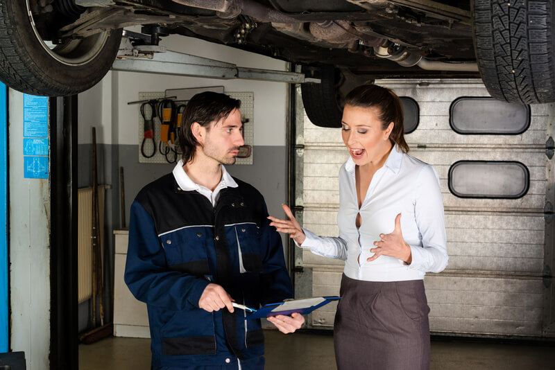 Auto mechanic explaining the bill to a customer