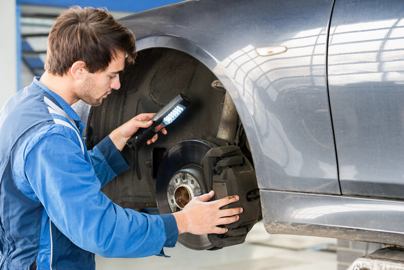 Auto mechanic inspecting brake pads